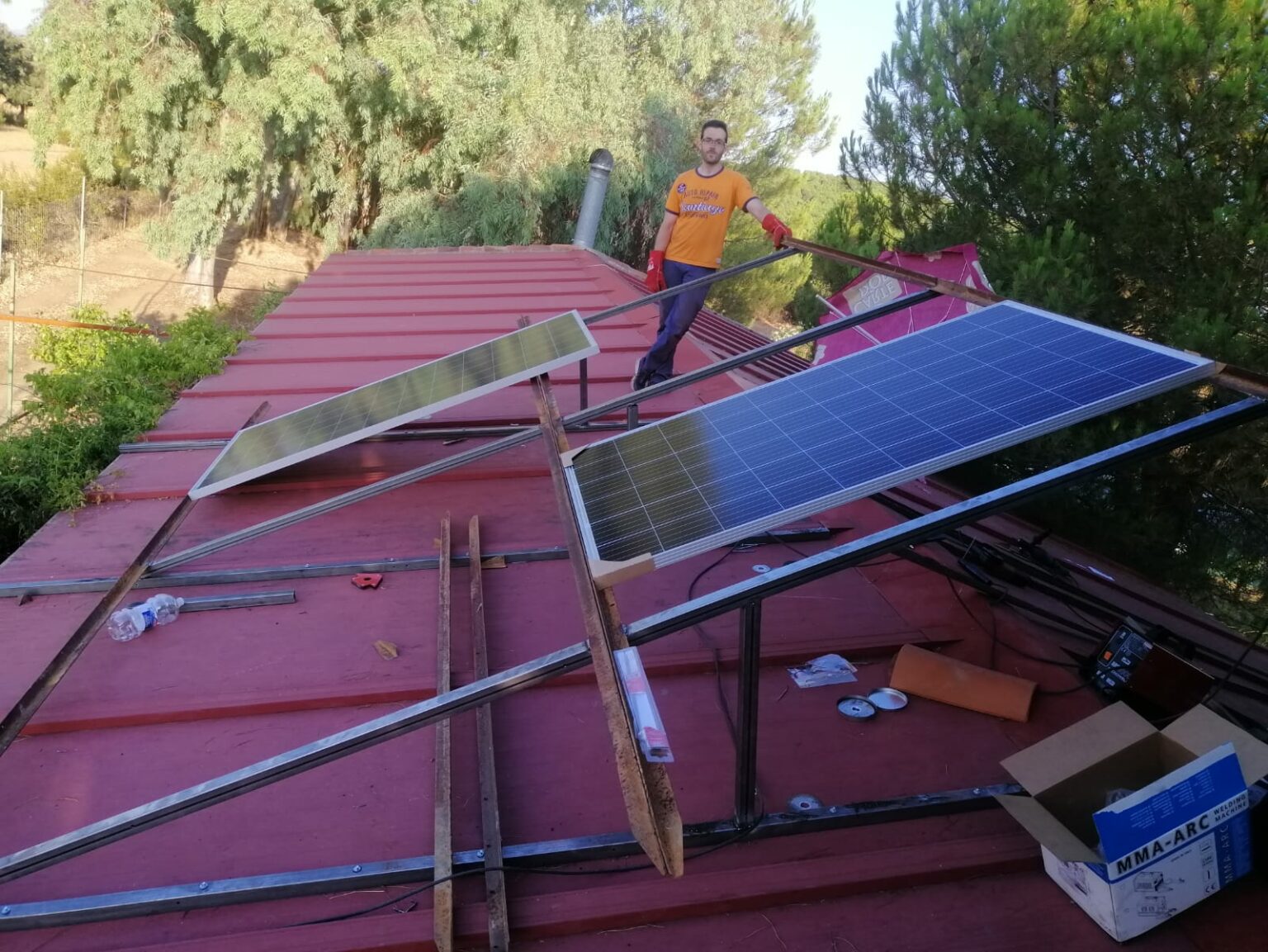 Operario instalando placas solares en casa de campo.