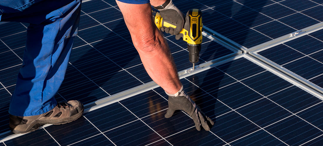 Instalador de placas solares haciendo un trabajo en un tejado para autoconsumo